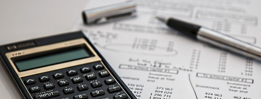 calculator and pen sitting on a financial statement
