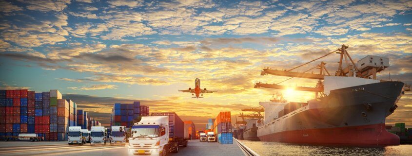 freight trucks, ship, and plane at sunset