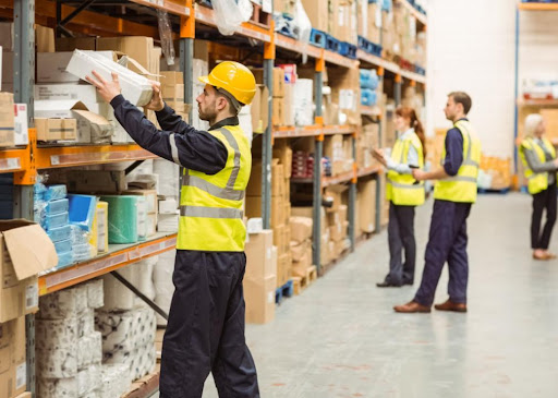 man stacking boxes on shelf in warehouse
