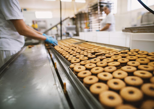 person working on donut assembly line