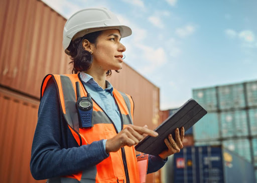 woman in orange vest supervising at storage container facility
