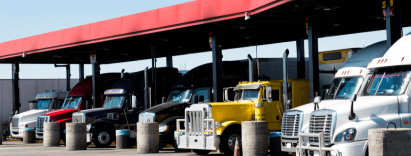 semi-trucks lined up at gas pumps