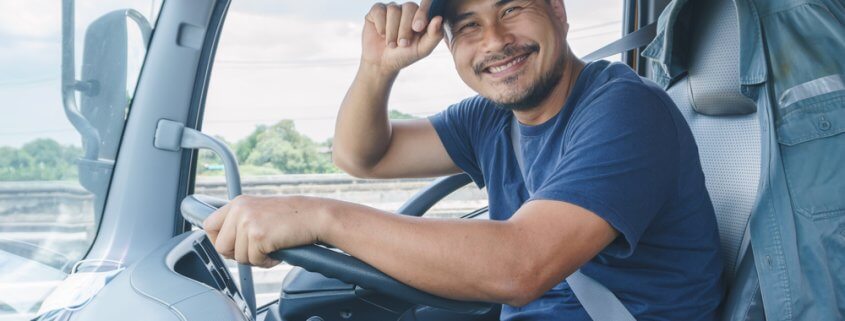 truck driver smiling in his semi-truck