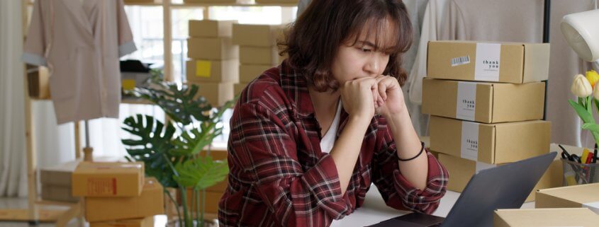 concerned small business owner looking at her laptop