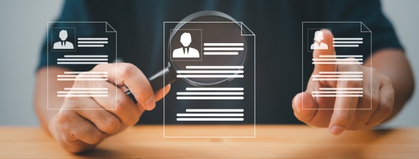 man with a magnifying glass over resume icons