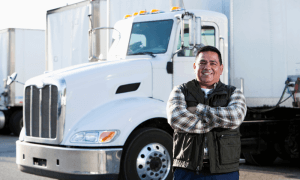 trucking business owner with his semi-truck behind him