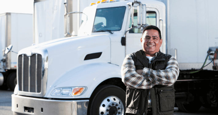 trucking business owner with his semi-truck behind him