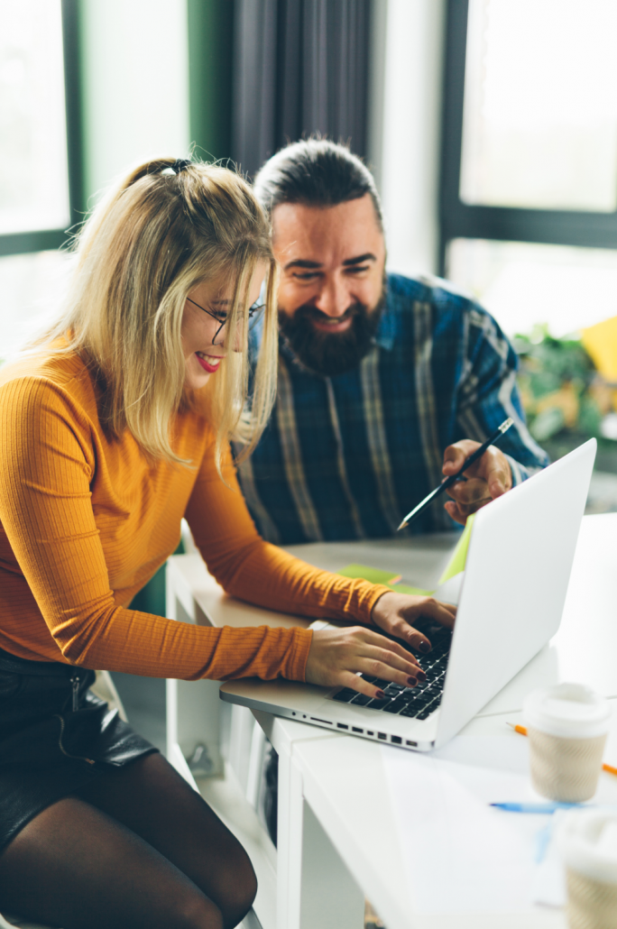 female and male business owners looking at laptop